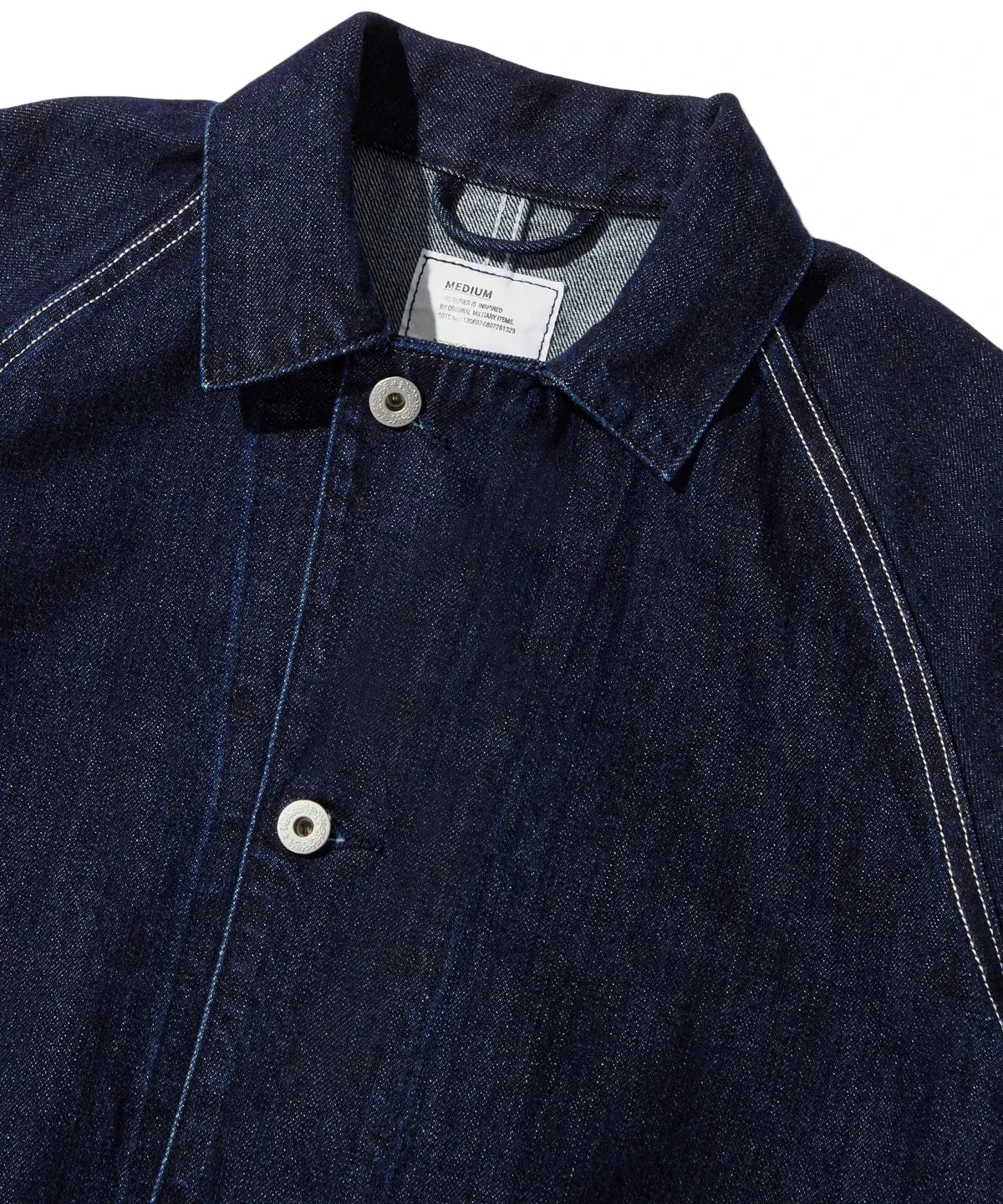 Navy denim shirt with white stitching on a light gray background