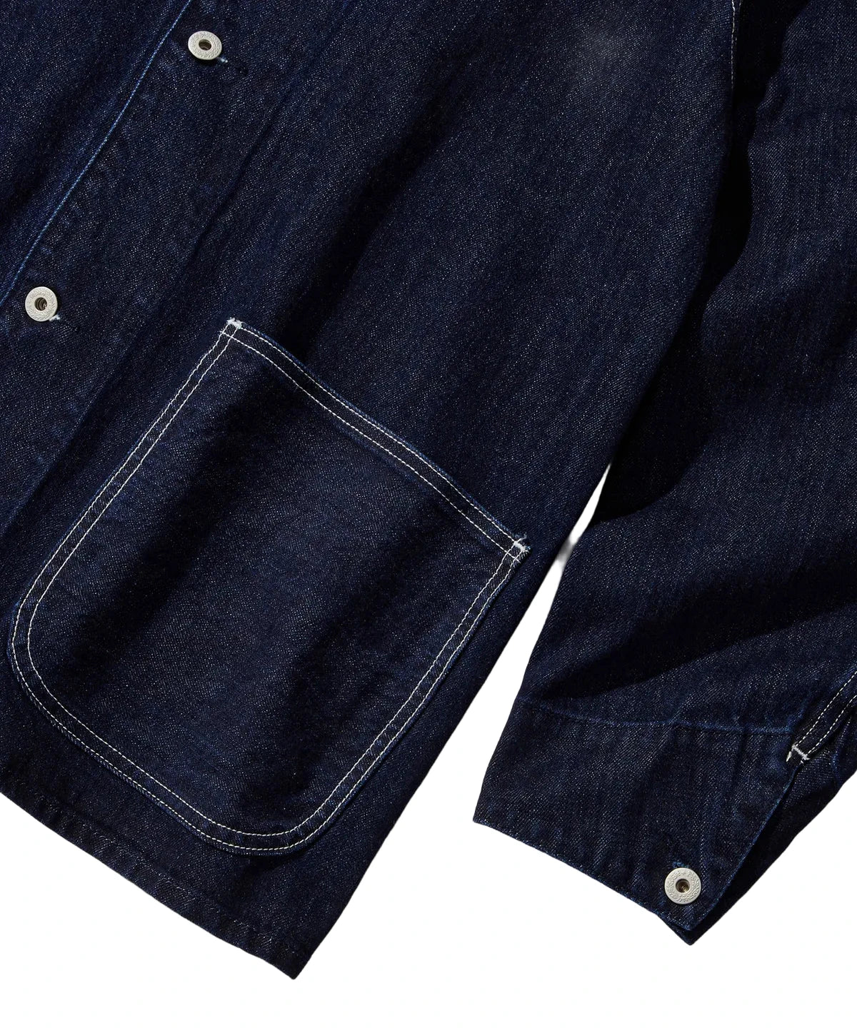 Close-up of a dark blue denim shirt with a pocket on a light gray background